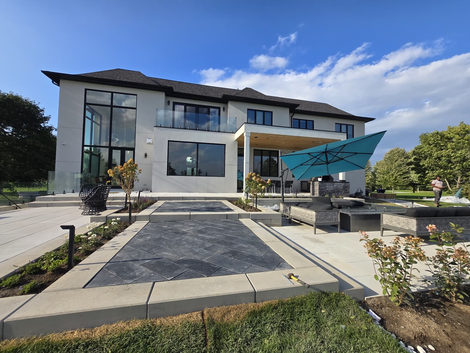 Backyard patio with lounge area and umbrella, landscaping Barrie