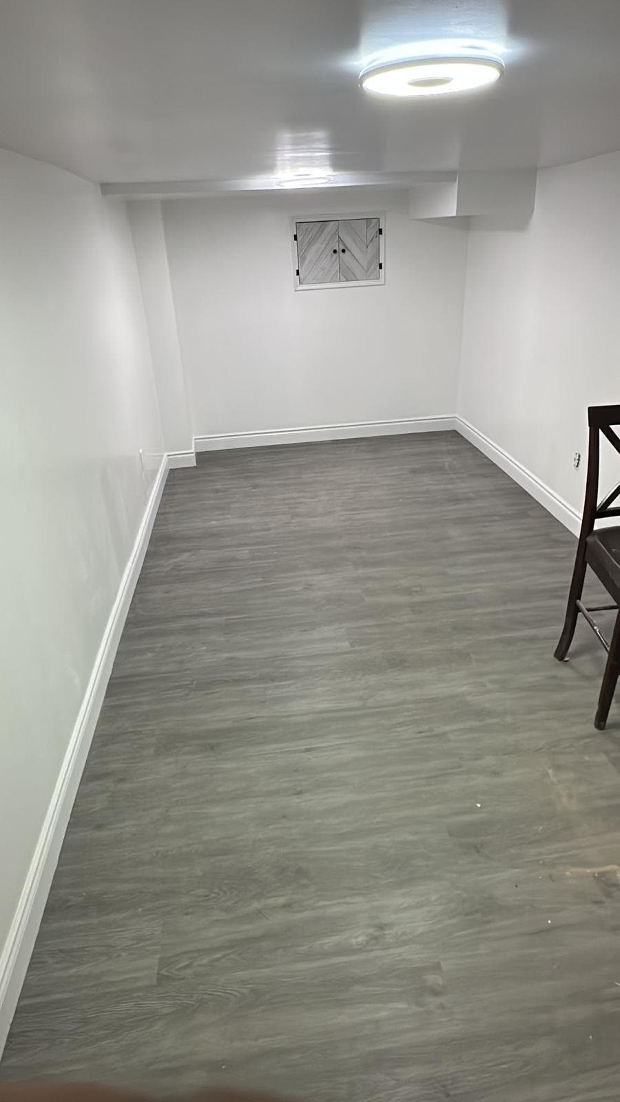 Finished basement room with wood-look flooring, Barrie renovation