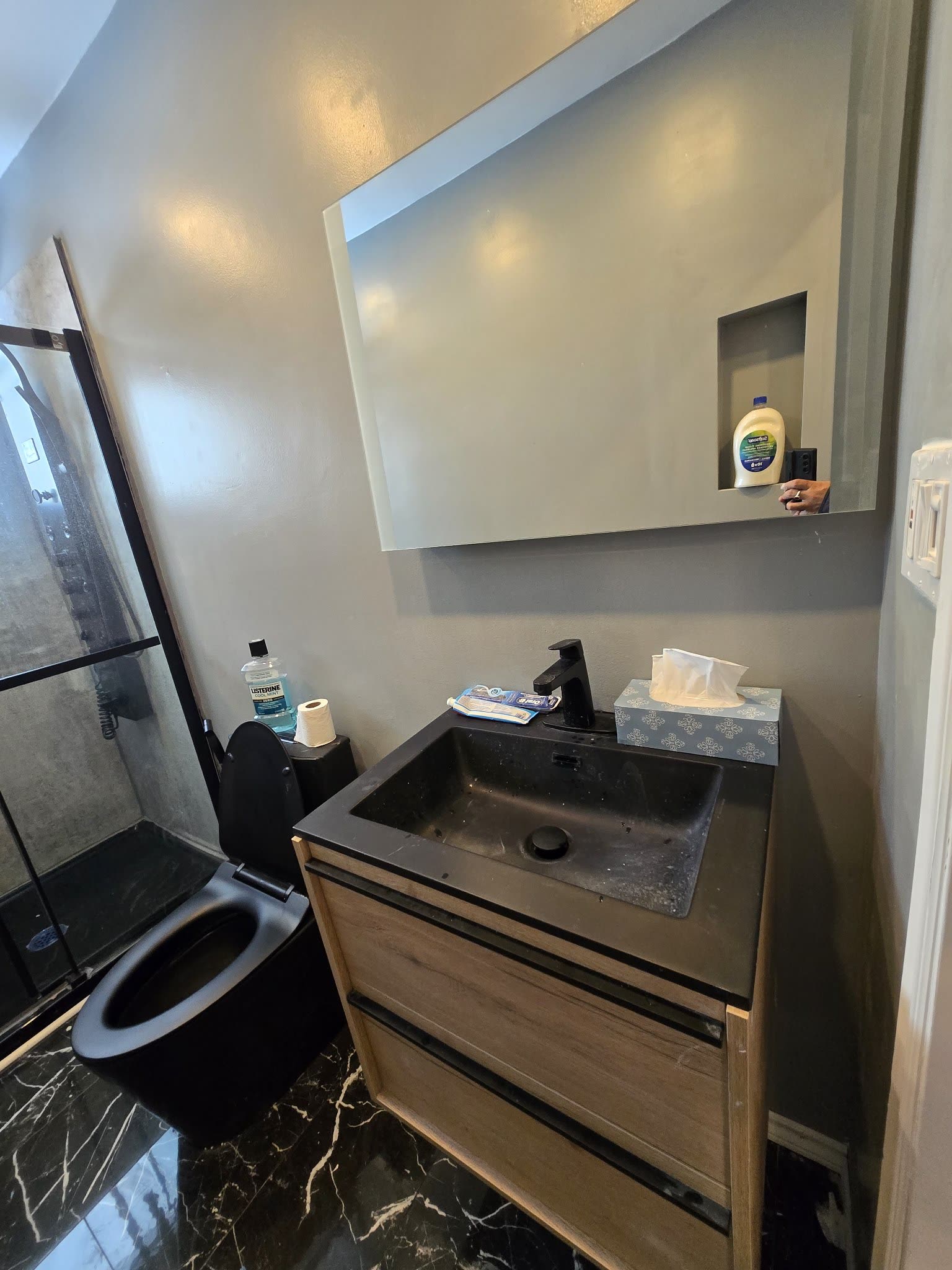 Modern bathroom with black toilet and wood vanity, Barrie Ontario