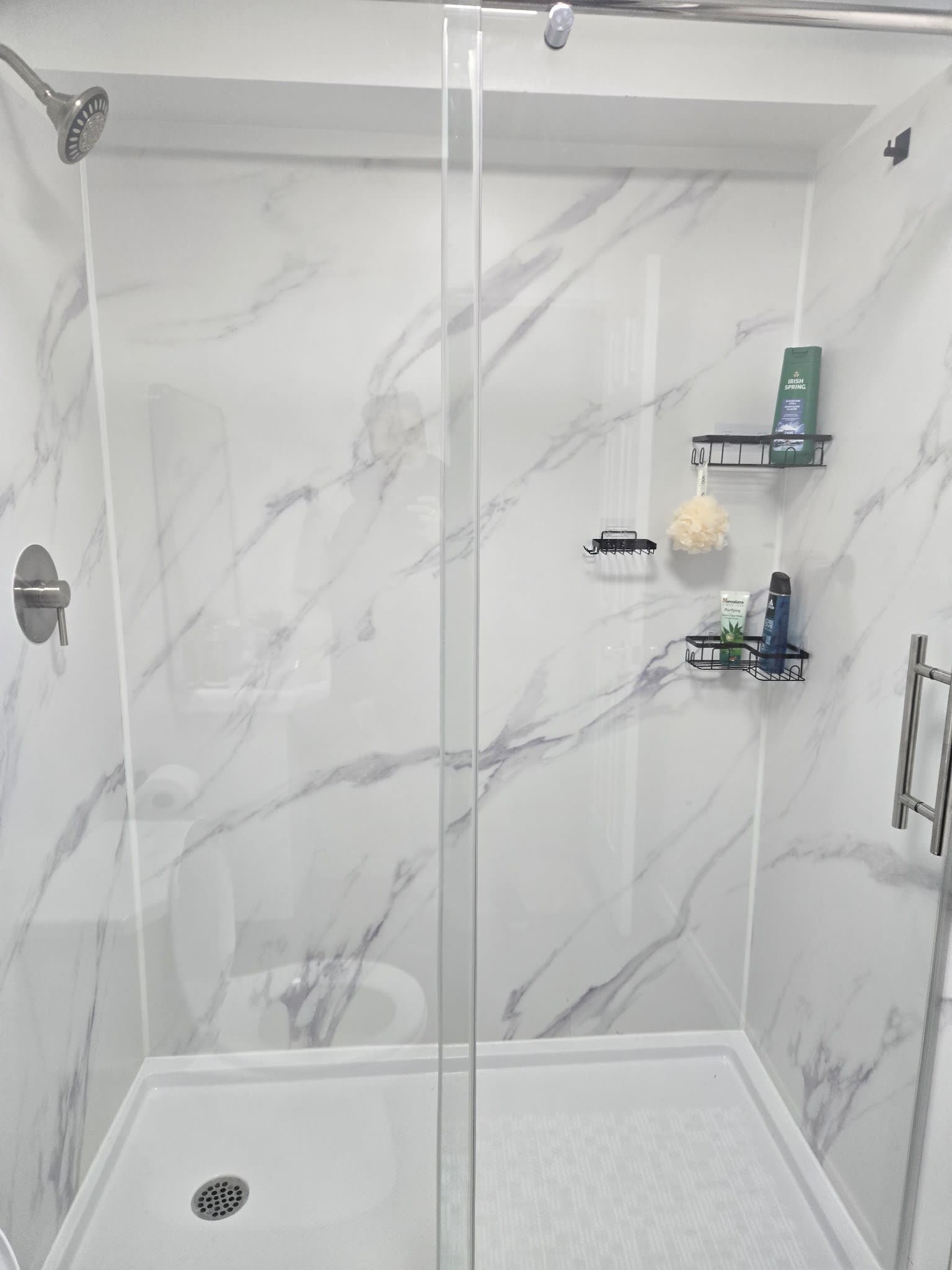 Walk-in shower with marble walls and black accessories, Barrie