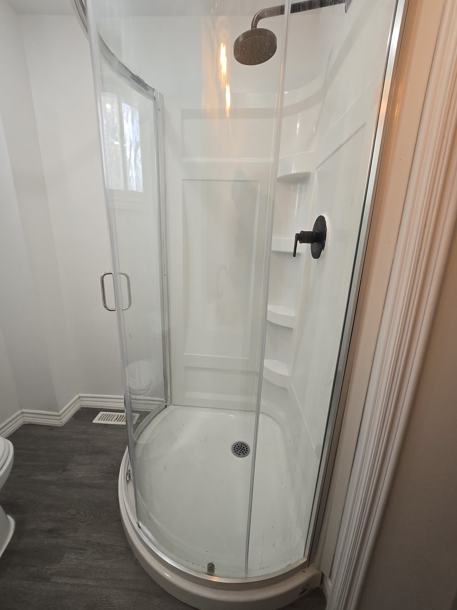Custom glass corner shower with rain showerhead installed in Simcoe County