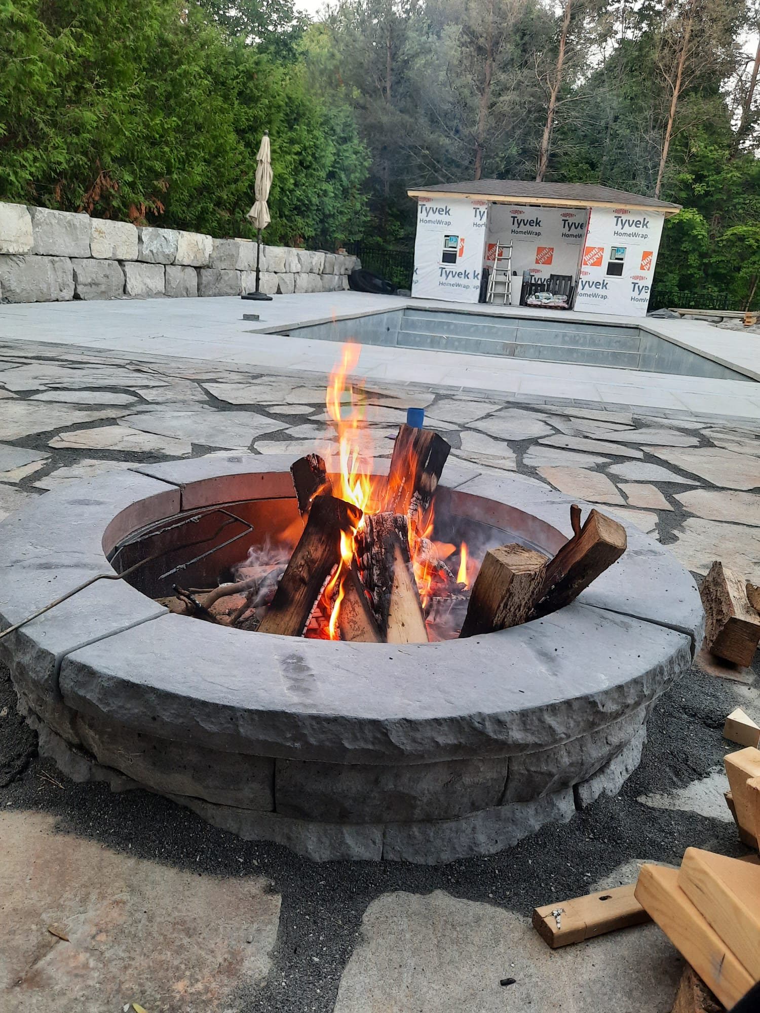 Wood-burning fire pit with flames on flagstone patio in Barrie