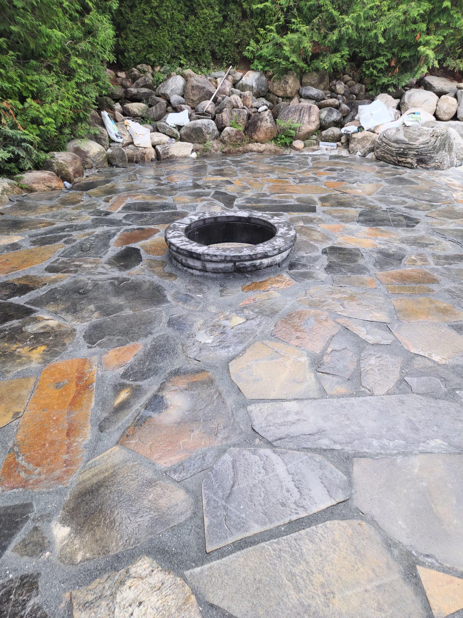 Custom stone fire pit installation in Simcoe County backyard