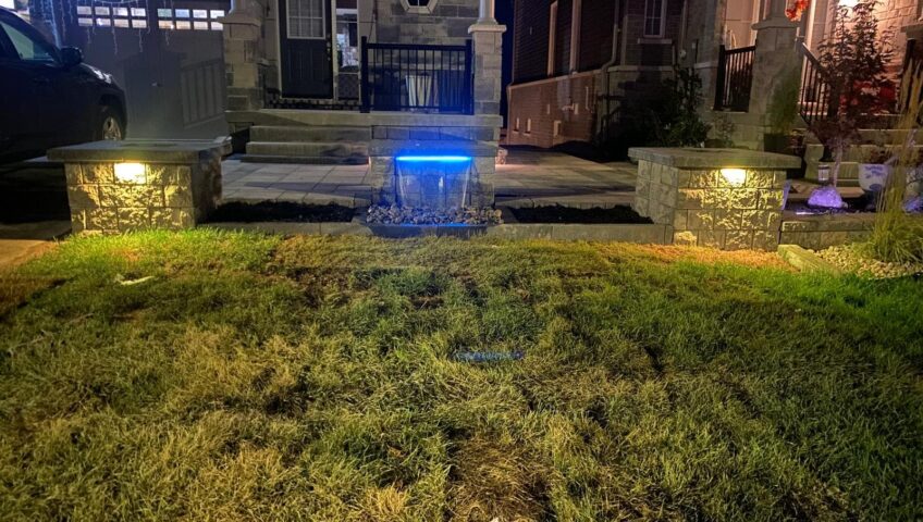 Front entrance of a Barrie home glowing with landscape lighting at night
