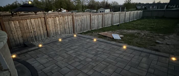 Interlocking patio with landscape lighting at dusk