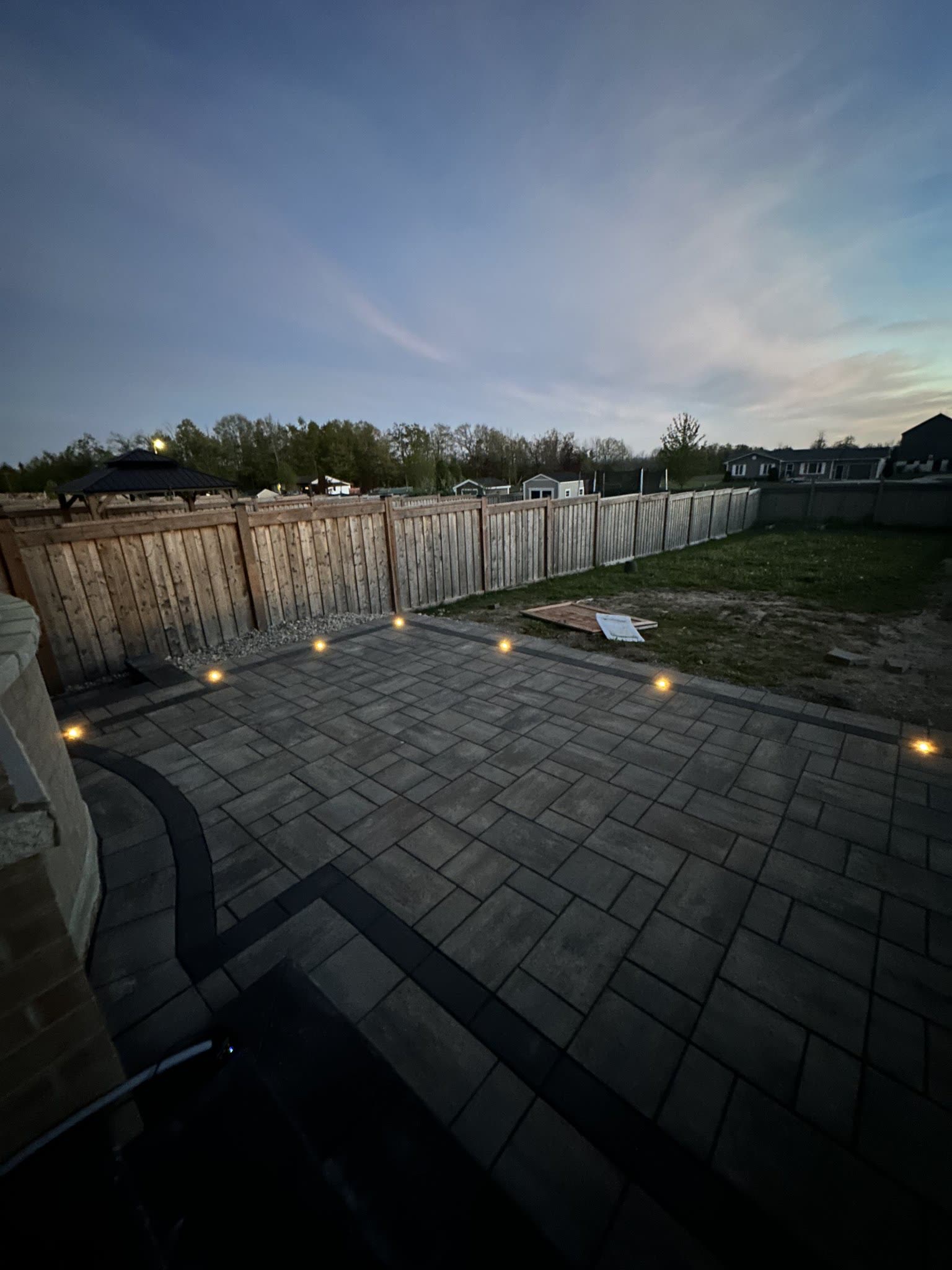 Interlocking patio with landscape lighting at dusk