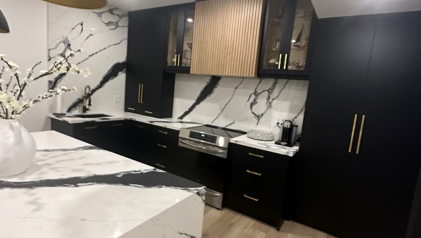 Luxury black and gold kitchen renovation with waterfall island in Barrie