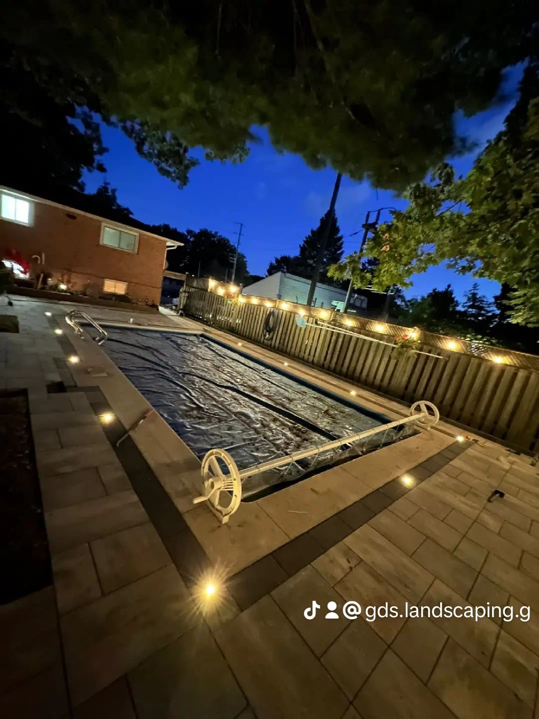 Landscape lighting around pool and interlocking patio in Barrie at night