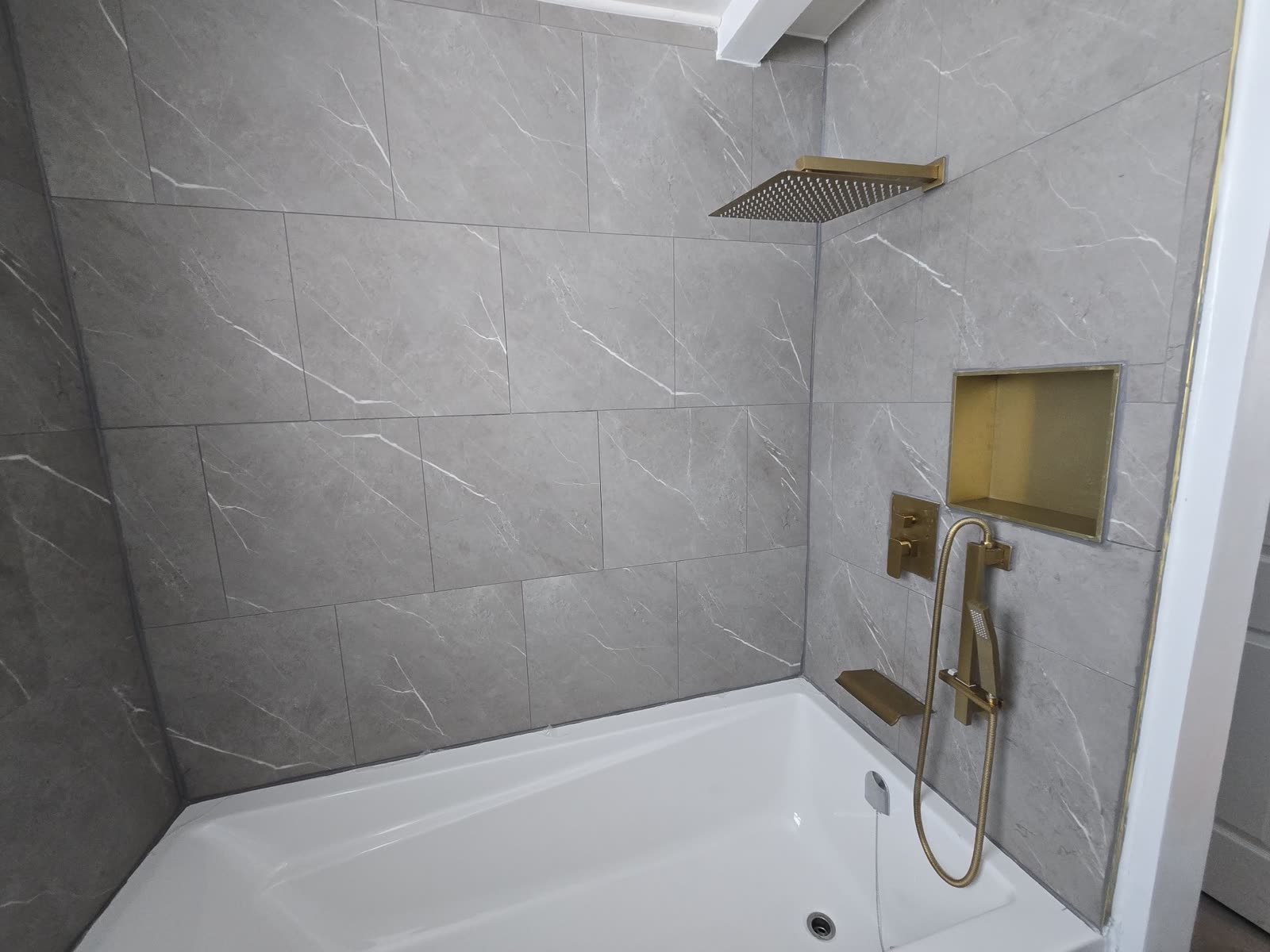 Tub and shower combo with marble tile and gold fixtures, Barrie