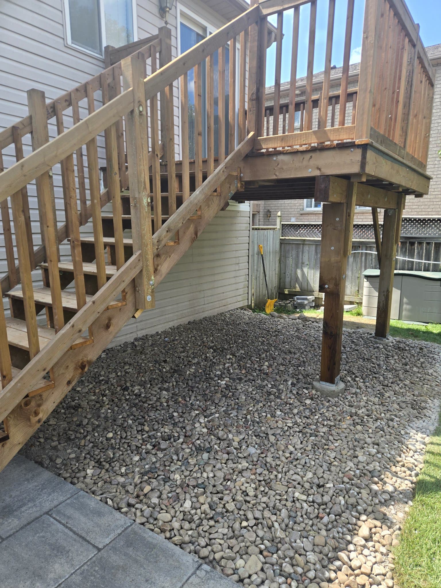 Wooden deck stairs with gravel bed underneath, backyard Barrie